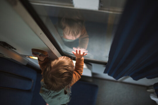 High angle view of curious boy leaning on train window