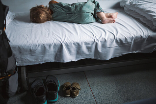 Rear view of boy sleeping on bed in train cabin