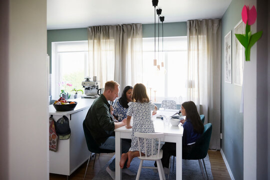 Family spending leisure time with each other at dining table of home