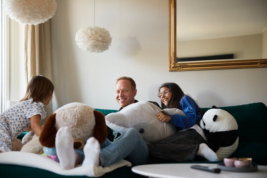 Carefree girls spending leisure time with father in living room at home