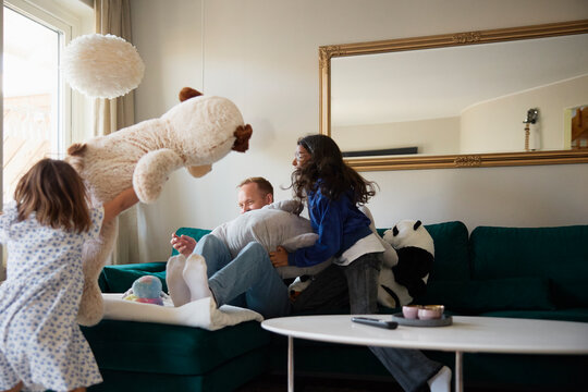 Carefree girls playing with father while spending leisure time in living room at home
