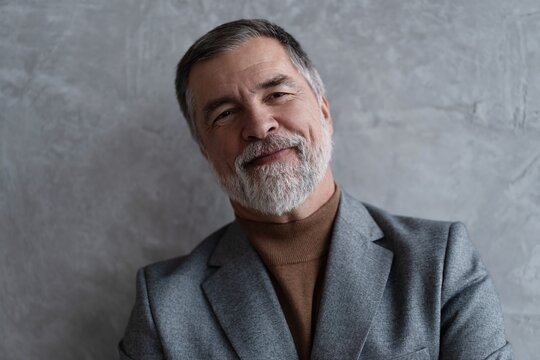 Entrepreneur in jacket smiling, Happy mid adult, mature age man standing, smiling, isolated on grey background
