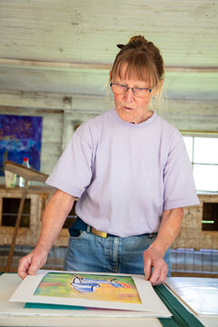 Senior woman making creative frame at home