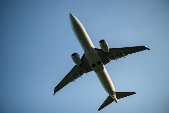 Directly below shot of plane flying against blue sky