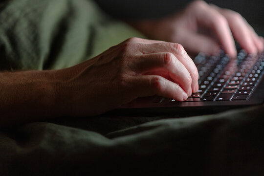 Hands of man using laptop at home