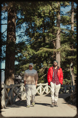 Obraz premium Two people walking along a forest path during a sunny day in Chakrata, Uttarakhand, India