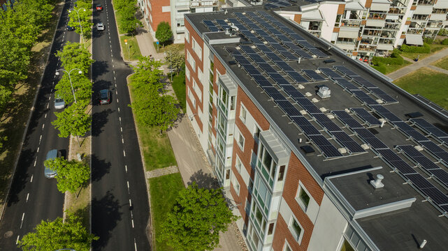 Drone shot of solar panels on building terrace near road at city