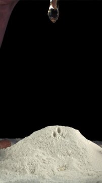 Super slow-moving men's hands cook baking at home. On a black background. Filmed on a high-speed camera at 1000 fps.