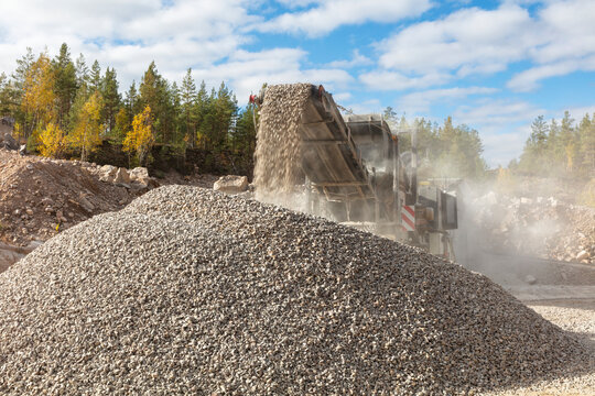 Industrial conveyor belt machine unloading crushed rock at quarry site