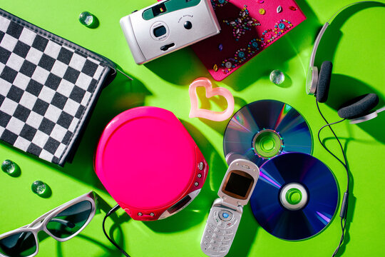 Vintage 2000s technology flat lay with flip phone camera and CD player