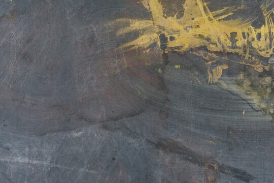 Dark textured background with energetic golden paint splatters and brush strokes.