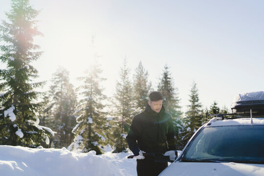 Man standing next to his car in winter season