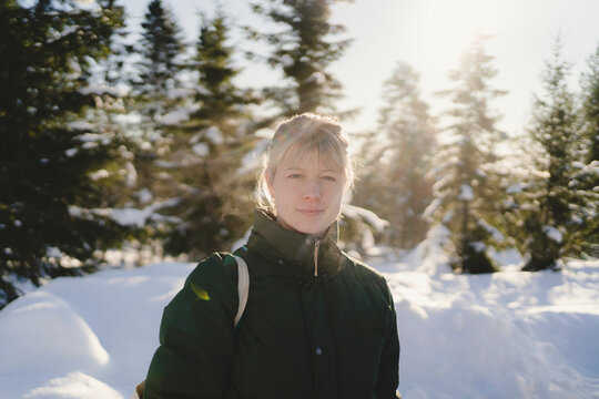 Young woman with blond hair in winter forest