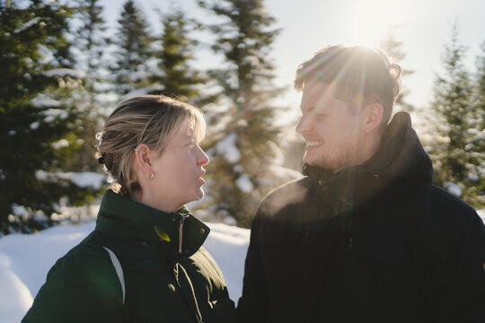 Man and woman in warm clothes talking at sunny day