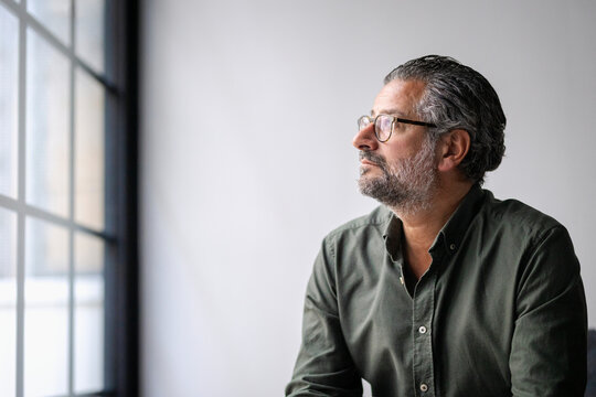 Contemplative mature businessman wearing eyeglasses looking away