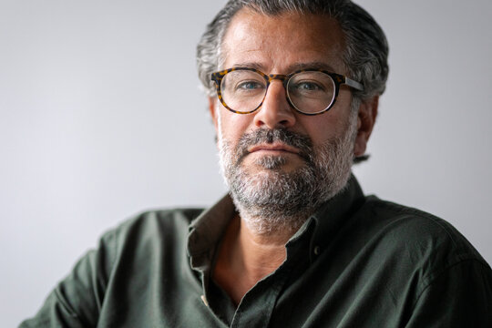 Headshot portrait of confident mature businessman wearing eyeglasses