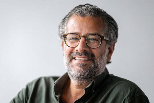Headshot portrait of smiling mature businessman wearing eyeglasses