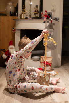 Full length of boy opening present during Christmas at home