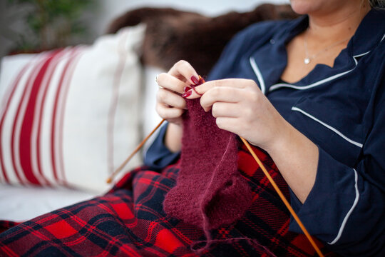 Hand of woman knitting cloth with needle at home