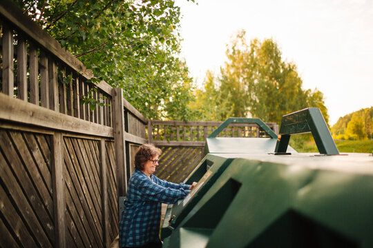 Woman throwing garbage in recycling bins