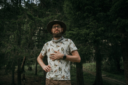 Portrait of smiling man wearing hat standing in forest