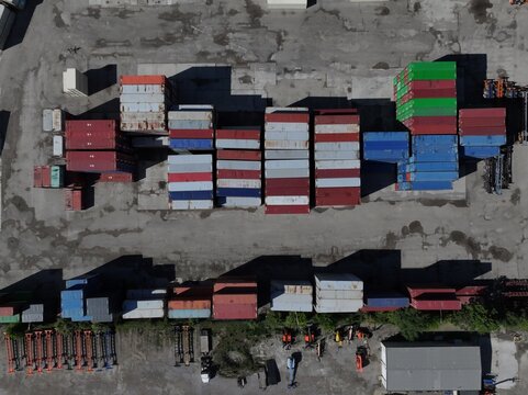 Aerial view of stacked colorful shipping containers in an industrial freight yard with asphalt ground Cincinnati, OH, United States.