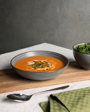 Bowl of fresh pumpkin soup served on table