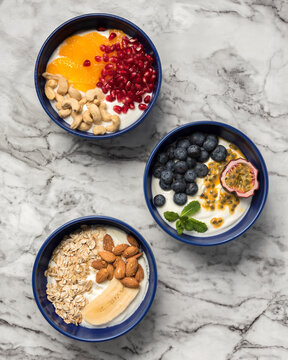 Directly above view of breakfast yogurt bowls with assorted fruits and nuts