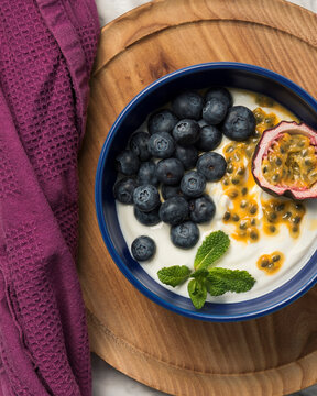 Close-up shot of fresh yogurt bowl with blueberries and passion fruit