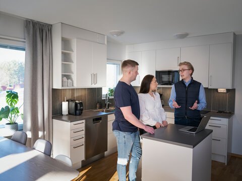 Male architect explaining home improvement plan to couple in kitchen