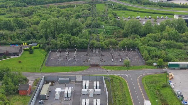 Substation with nearby BESS Battery Energy Storage System installation made of lithium-ion. Modern green energy infrastructure, smart grid technology, sustainable power solutions in UK.