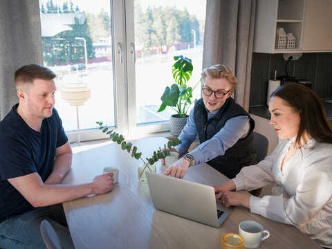 High angle view of male building contractor explaining plan to woman on laptop during renovation