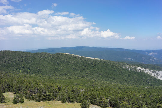 Panoramic scenic view of Mount Ida (Kaz Daglari) national park with green pine forests, rocky slopes, and misty mountain ranges under a clear blue sky. Nature tourism, hiking, and travel  in Canakkale