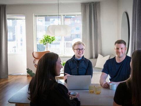 Family members sitting with male agent at table in home