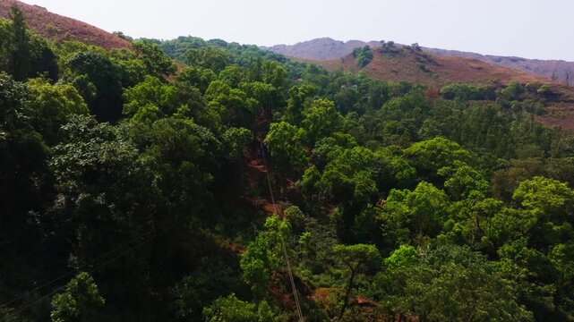 Zip Line with reserved forest, mountains and sky, at Western Ghats, Attigundi, Inam Dattathreya Peeta, Chikkamagaluru, Karnataka, india. day time, push back shot, drone shot, 4k.