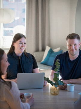 Smiling man having coffee while sitting with agent in home