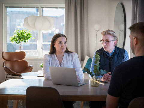 Woman listening to agents while sitting at table in home