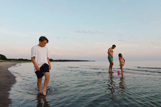Family members spending leisure time at beach sea water under sky