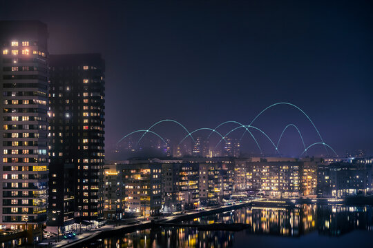 Digitally generated image of network lines above illuminated city buildings against clear sky