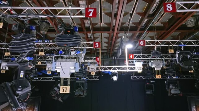 Industrial lighting rig moving upward inside a television studio production set.