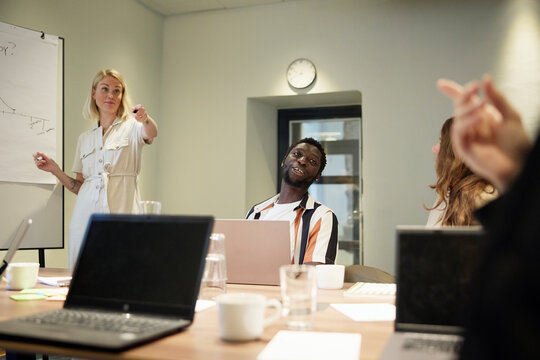 Female manager interacting with colleagues in team meeting