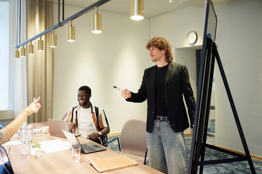 Manager interacting with coworkers during brainstorming session in meeting room