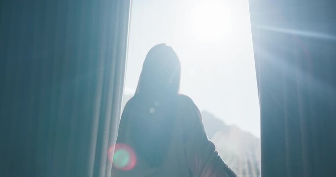 Woman, light and open with curtains in home for morning, stretching or new day in bedroom. Back view, female person or awake with lens flare, window or sunshine for start, rise and shine in house