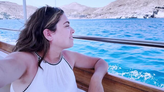 Woman vlogging on a boat trip in santorini