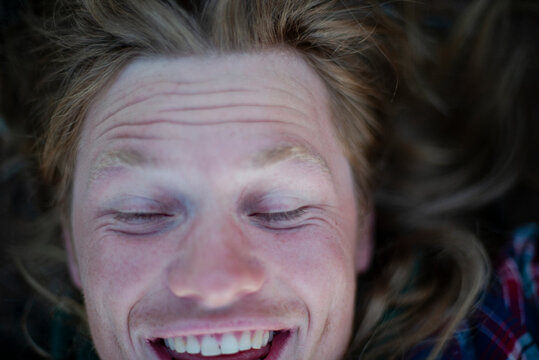 Directly above shot of happy man with eyes closed lying down outdoors