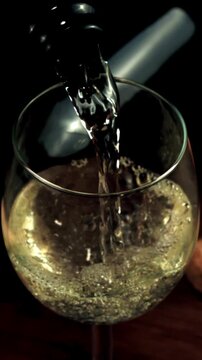 From the bottle pour champagne into the glass. On a dark background. Filmed is slow motion 1000 frames per second. High quality FullHD footage