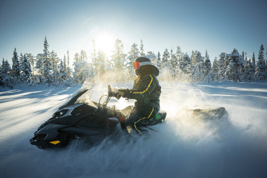 Shot of person driving snowmobile on bright sunny day