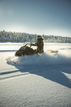 Shot of person driving snowmobile on winter day