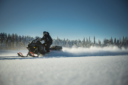 Person riding snowmobile on landscape covered in snow