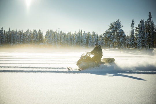 Shot of person riding snowmobile on bright sunny day